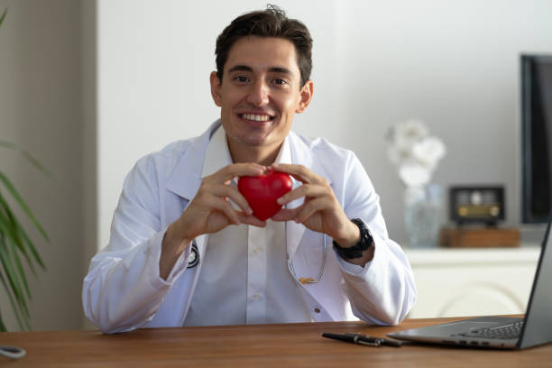 istock Young general practitioner smiling looking at camera with red heart in hand 2170411074