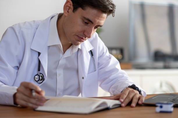 istock Handsome male doctor checks his availability on his diary 2170411086
