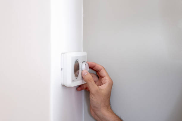 istock Close-up of unknown man adjusting room temperature with thermostat 2170411227