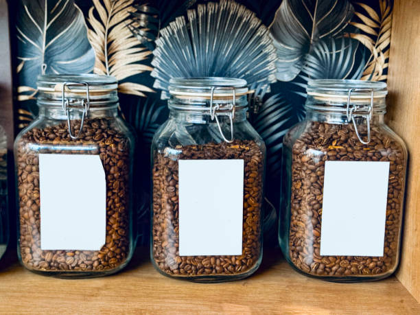 Coffee beans in a glass jar on a wooden table.