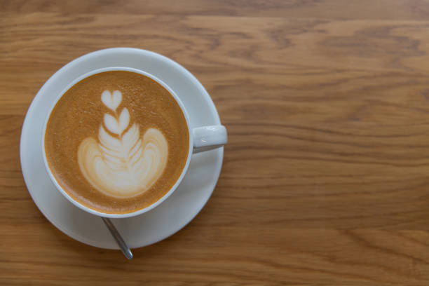 Table top view of white porcelain cup of cappuccino with latte art \