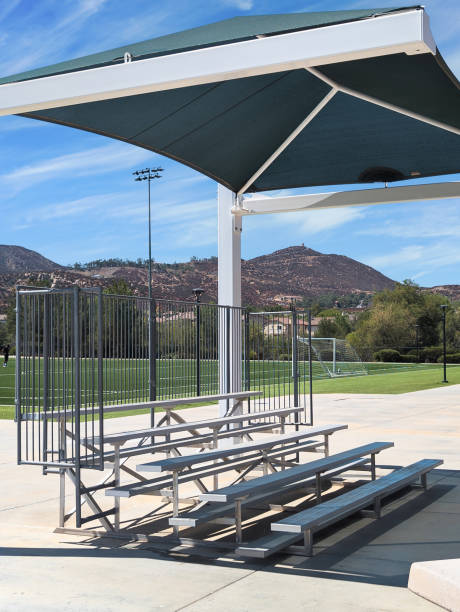 istock Empty metal aluminum bleachers under a shade structure by a baseball field 2170415983