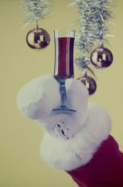 Santa Claus wearing white boxing gloves toasts with wine at the Christmas party.