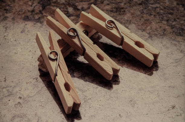 Set of vintage weathered wooden clothespins on a jute rope isolated on white