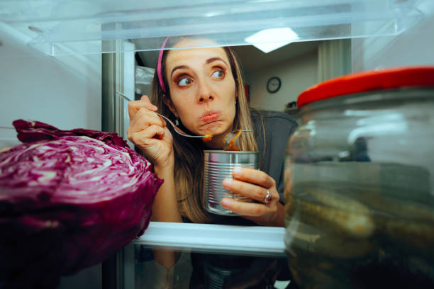 istock Funny Woman Eating from a Can looking in the Fridge 2170434230