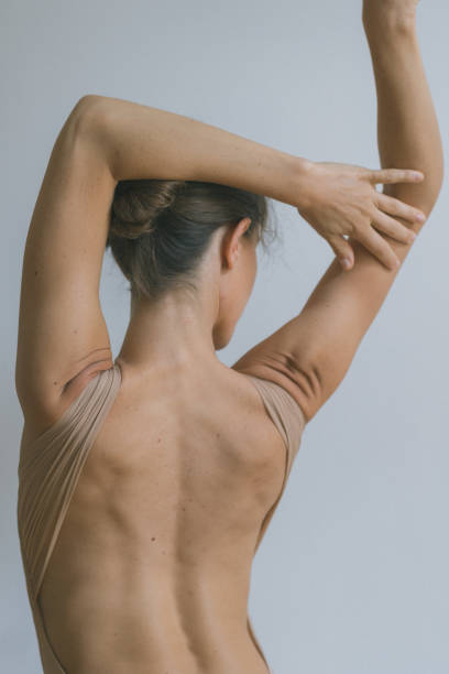 Woman massaging back pain on white background.  “Image is not body shape retouched”