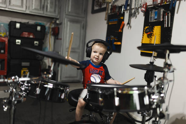 istock Cute little drummer playing drums while listening music 2170435818