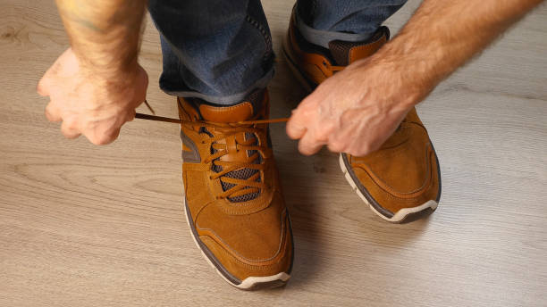 istock A man is tying the laces on his brown shoes 2170435985