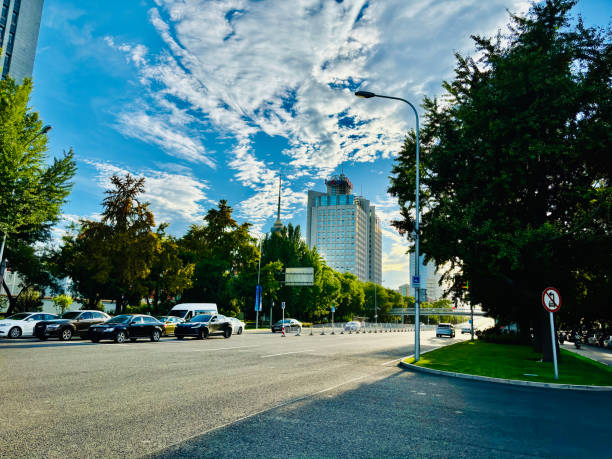 This captivating image captures a picturesque view of the sky from the road, where vibrant hues of the clouds create a serene contrast against the urban landscape below.