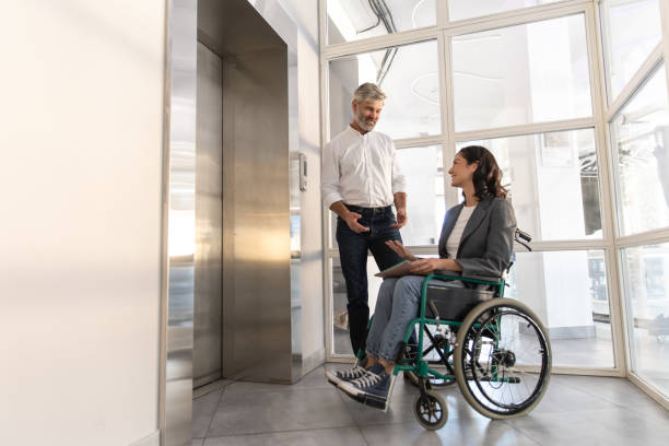 istock Businesswoman with disabilities with man posing in office hall 2170445528