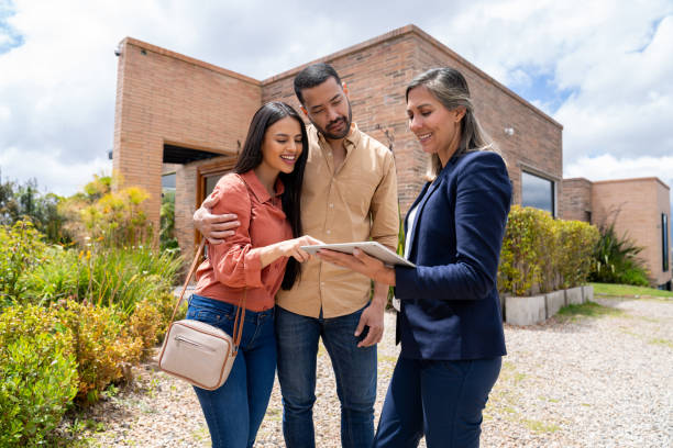 istock Real estate agent using a digital tablet while showing a house to a couple 2170446032