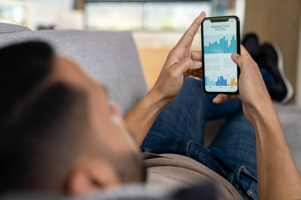 istock Man working from home on his cell phone while lying on the couch 2170446134