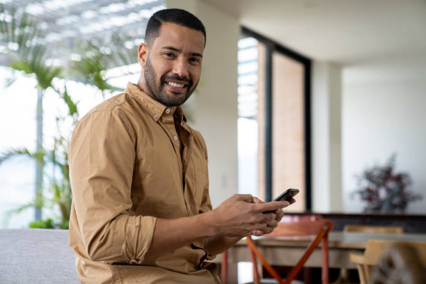 istock Man at home texting on his cell phone and smiling 2170446146