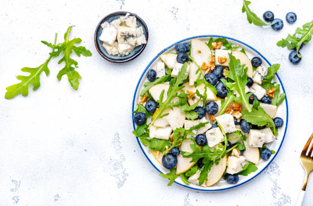istock Gourmet salad with pears, blueberries, gorgonzola cheese, arugula and walnuts. White background, top view 2170453817