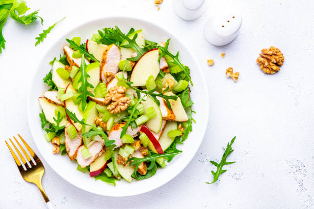 istock Old fashioned salad with chicken, red and green apples, raw celery, lettuce and walnuts, white background, top view 2170453818