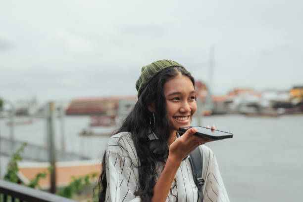 Young Asian using AI Translator Application on Smartphone for Mode of transportation in Bangkok.