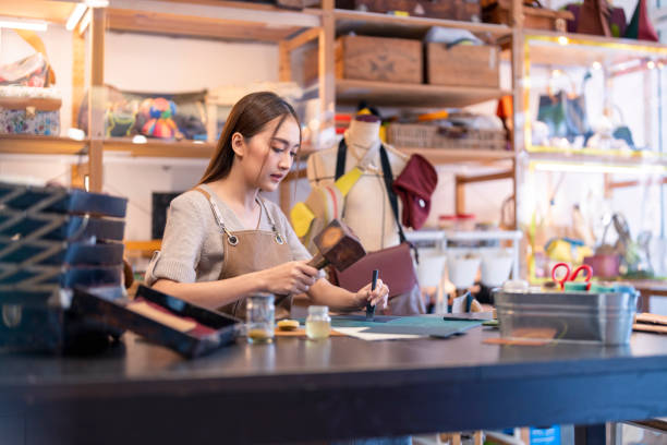 istock Leather studio craftman asian artisan working with leather bags part while gluing piece bag handle,The process of gluing leather tanned leather craft materials by a craftsman 2170459154