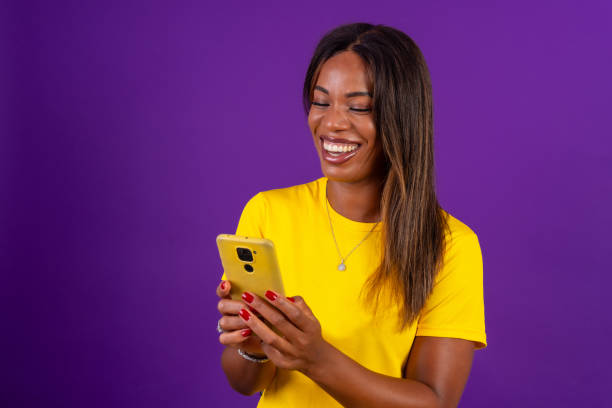 istock Happy african urban woman using mobile phone while smiling 2170462399