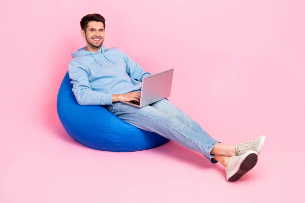 istock Photo of positive man professional it specialist sit comfy bag work from home empty space isolated on pink color background 2170464942