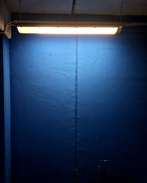an underground garage or entrance hall made of roughly processed concrete is created. the modern blue paintwork is illuminated from the ceiling. spot light.