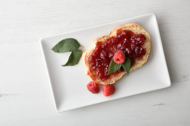 istock Slice of bread with raspberry jam with berries on plate 2170467077