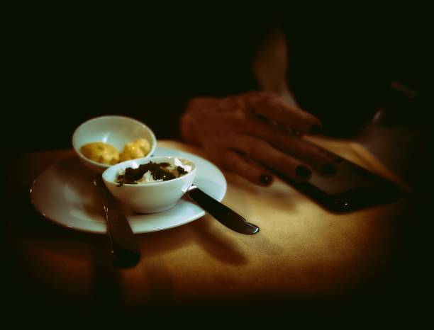 Close-up of housewife putting sauce in bowl during dinner at dining table