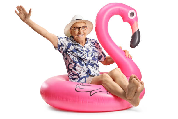 istock Elderly man sitting on a big inflatable flamingo rubber ring 2170468413