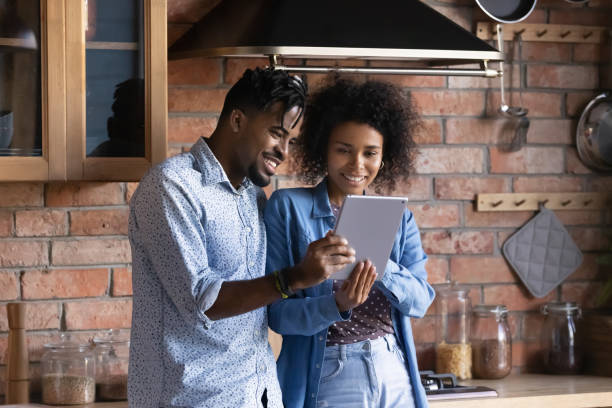 istock Happy African American young couple using tablet in kitchen together 2170468540