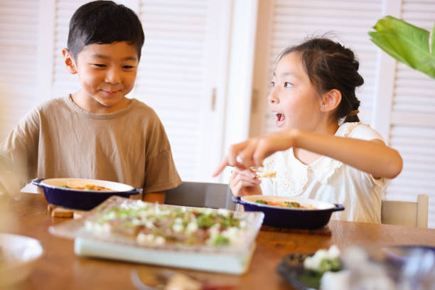 istock Happy Children enjoying a meal together 2170469024