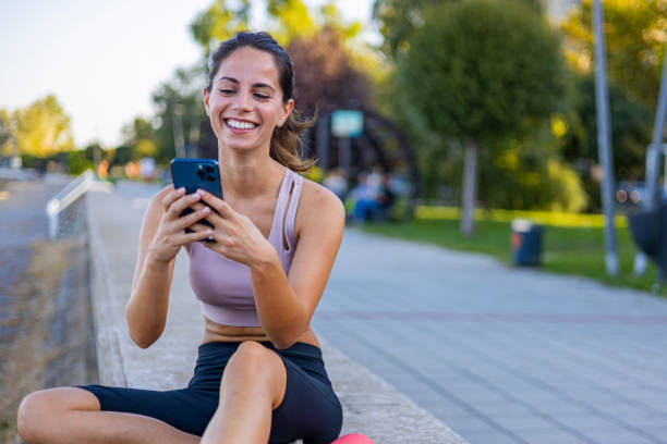 istock Young Woman Smiling While Using Smartphone Outdoors 2170474886