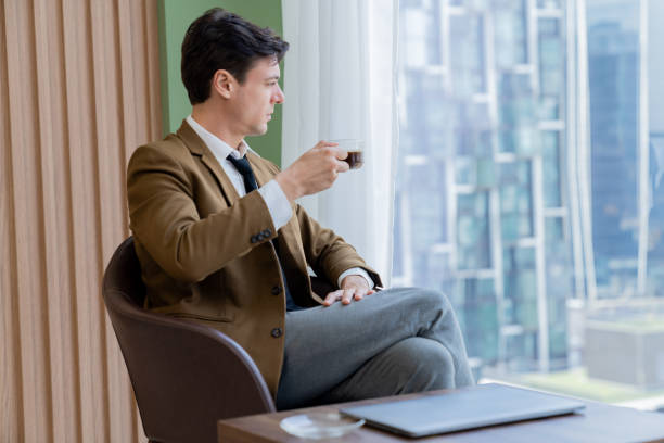 istock Smart businessman holding coffee cup while looking skyscraper view. Ornamented. 2170476262