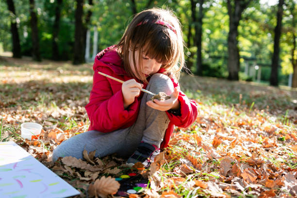 istock Girl playing while painting a rock in nature 2170477457
