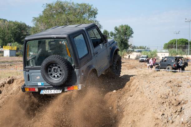 Sant Celoni, Spain – August 17, 2024: Rear view of a small gray second generation Japanese Suzuki Smaurai SUV going up a dirt slope
