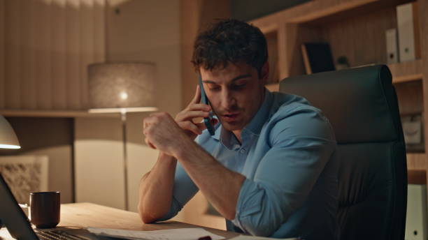 istock Busy worker calling cellphone working at dark workplace agency close up. 2170478561