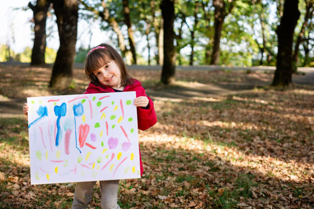 istock Girl holding her drawing in nature 2170481012