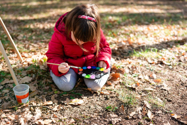 istock Girl having fun painting autumn leaf 2170481341