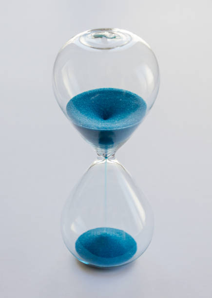 istock Hourglass containing blue sand isolated on white background 2170485166