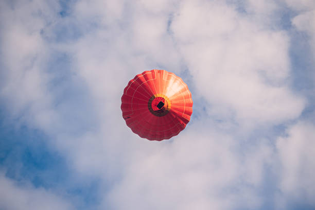 Black and red hot air balloon mid air at dusk.