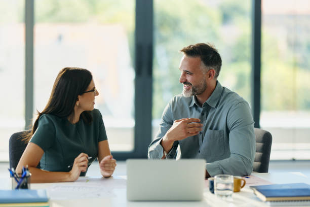 istock Happy business colleagues talking in the office. 2170486640