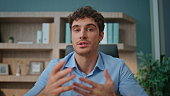 pov-entrepreneur-talking-camera-interview-in-office-online-coach-waving-hand.jpg?b=1&s=170x170&k=20&c=-DfKIJ77ynuVXmSjjxCa-PpdQxBXDcADgRvv8EUaoI8=