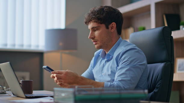 istock Busy worker answering smartphone at workspace. Corporate man make notes on call 2170493728