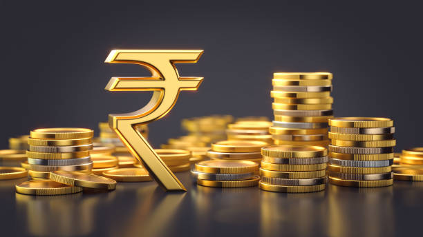 istock Indian rupee symbol with stacks of coins on a dark background 2170497193