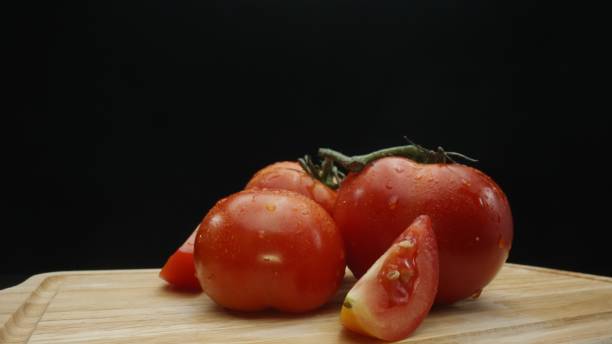 istock Macrography, slices of tomato placed on board with black background. Comestible. 2170497745