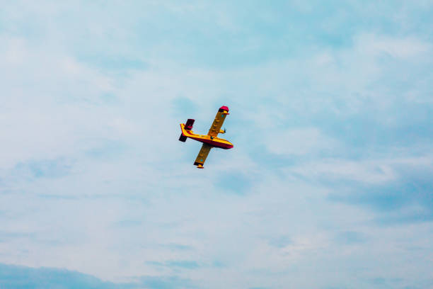 istock Small airplane. Yellow red Propeller plane is flying on blue sky 2170498401