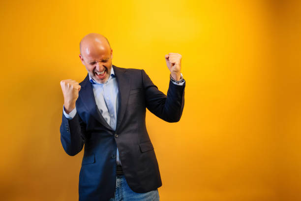 istock A man with a beard and a suit euphorically celebrating a victory. 2170498811