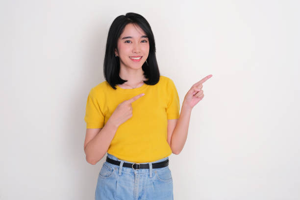 istock Young women smiling and pointing beside her 2170501172