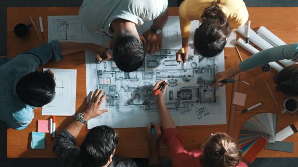 istock Top down view of engineer team writing at blueprint at meeting table. Symposium. 2170505596