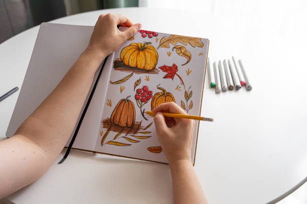 istock Hand drawing colorful autumn-themed illustrations in sketchbook 2170506338