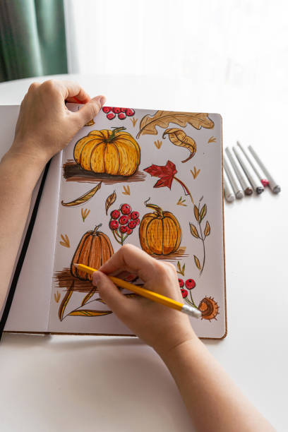 istock Hand drawing colorful autumn-themed illustrations in sketchbook 2170506345