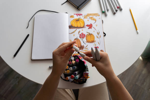Hand coloring autumn-themed illustration with markers
